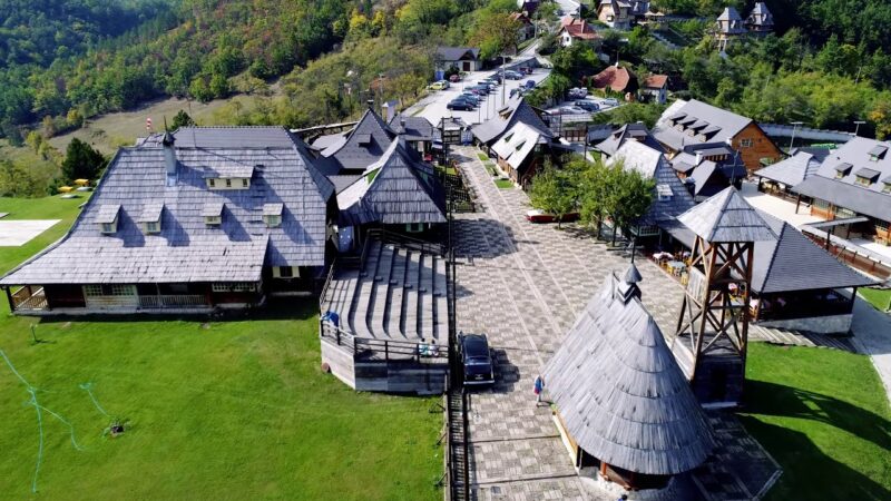 Vazdušni pogled na Drvengrad – Mećavnik, jedinstveni etno-selo sa tradicionalnim drvenim kućama smeštenim na brdu, okružen prirodom.