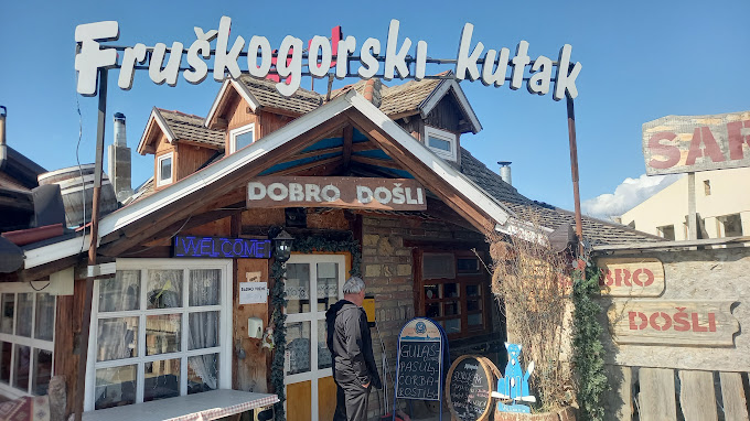 Ulaz u restoran Fruškogorski kutak, prikazan sa natpisom 'DOBRO DOŠLI' i drvenim etno elementima.